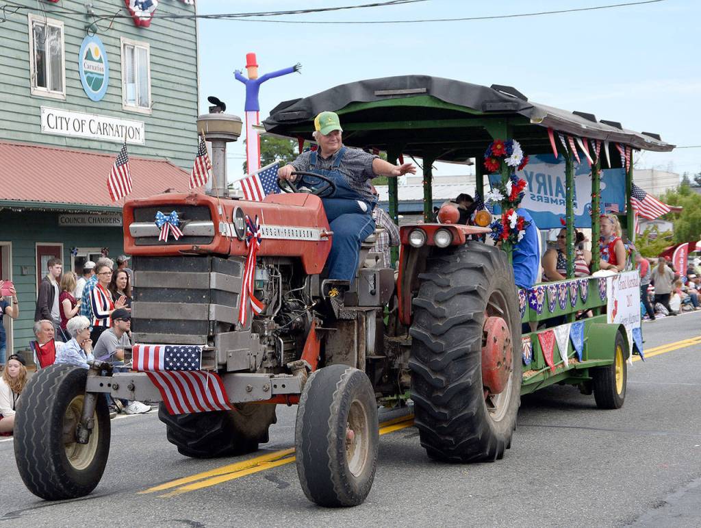 Grand Marshal George Magnochi waves to the crowd as he drives his float in the Grand Parade. (Carol Ladwig Staff Photo)