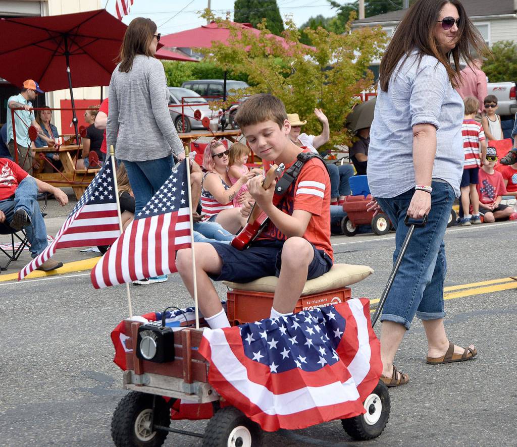 A youngster strums his guitar in the Carnation Kiddie Parade. (Carol Ladwig Staff Photo)