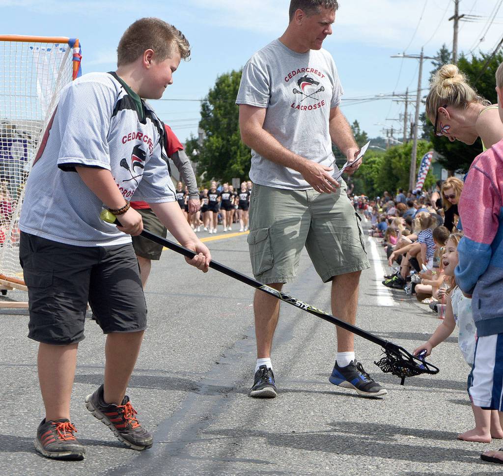 Riley flashes a brilliant smile when she&rsquo;s offered candy from the Cedarcrest Lacrosse team. (Carol Ladwig Staff Photo)