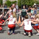 Softball all-stars lead a cheer in front of the parade stage. (Carol Ladwig Staff Photo)