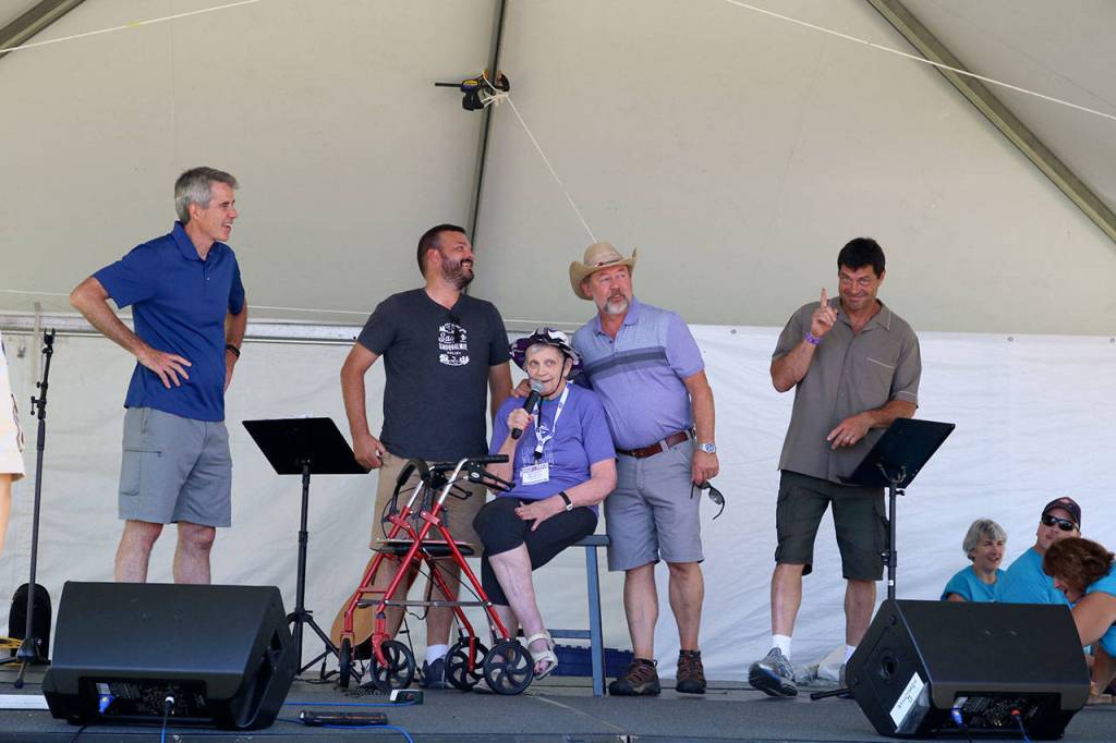 Bev Jorgensen brings representatives from Valley communities to the stage. From left, Snoqualmie Mayor Matt Larson, Deputy Mayor of Carnation Dustin Green, North Bend Mayor Ken Hearing, and President of the Fall City Parks Commission Perry Wilkins. (Evan Pappas/Staff Photo)