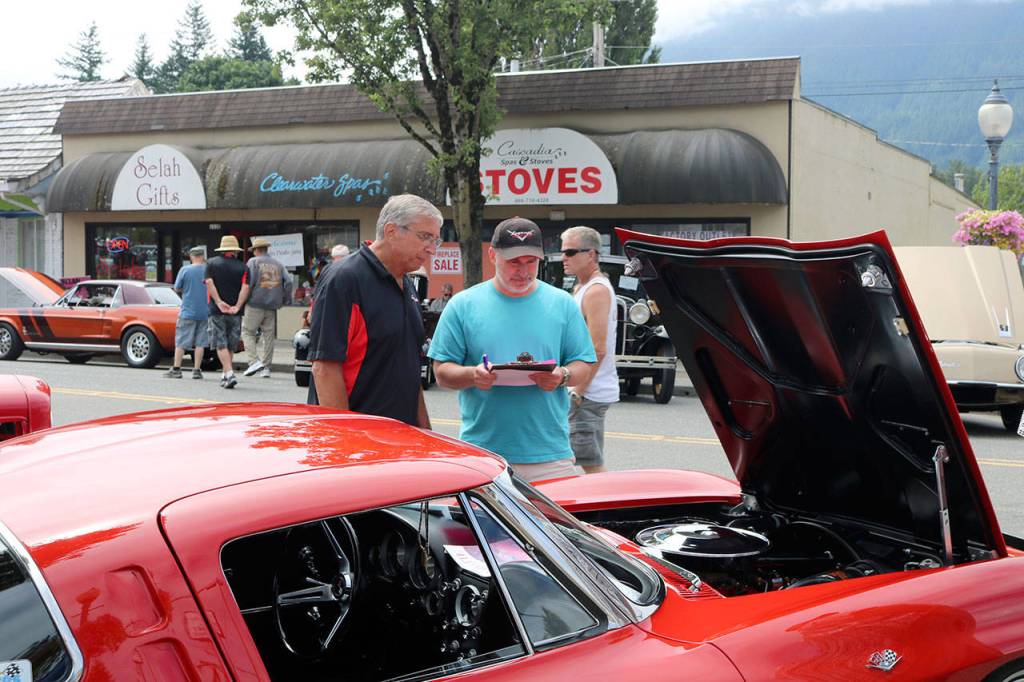 Legends Car Club judges look at the cars on display and make notes for the awards. (Evan Pappas/Staff Photos)