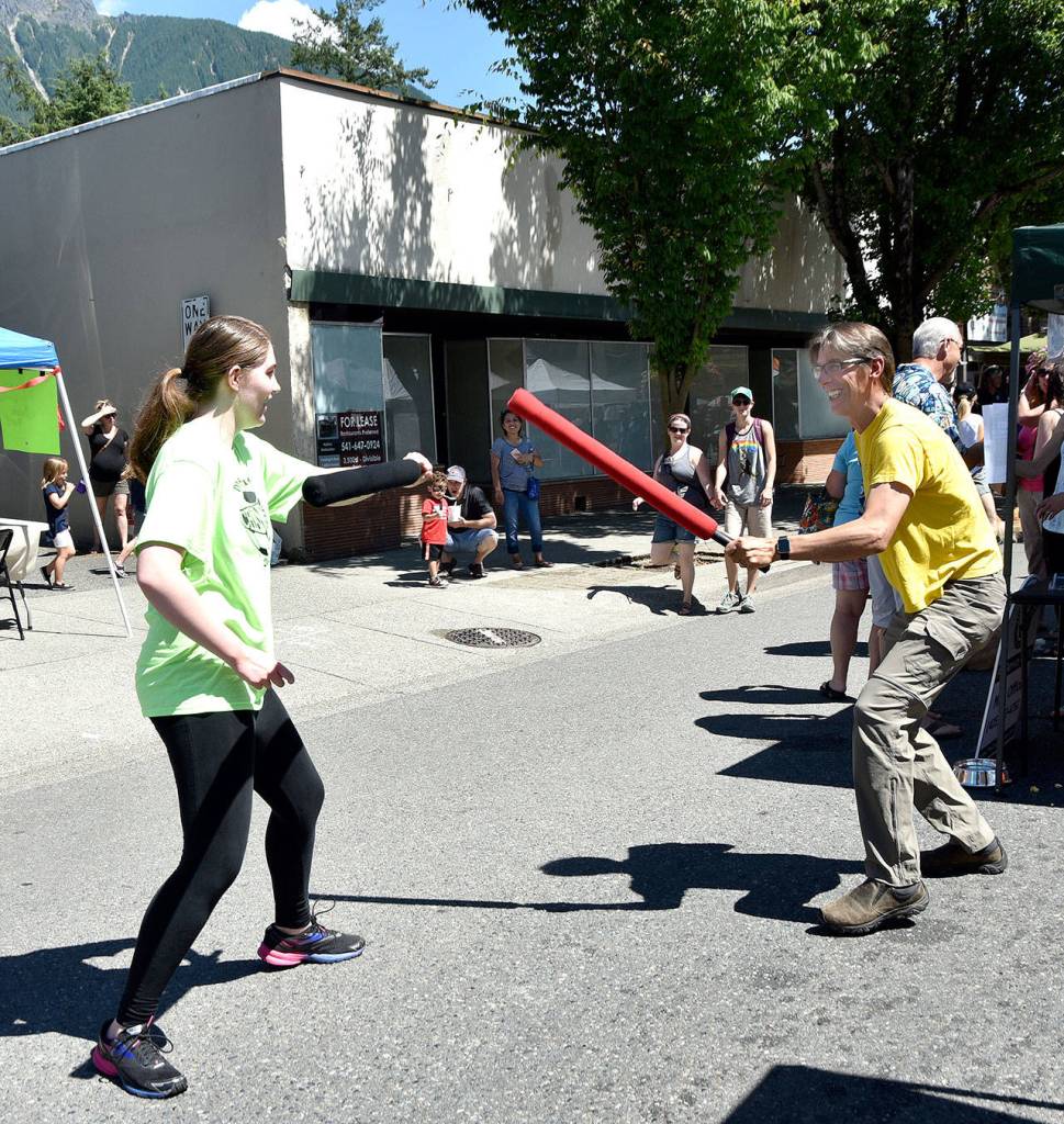Washington Fencing Academy student Allison Beedle spars with the father of another student, both of them left-handed, at the academy&rsquo;s Block Party booth, Saturday. Carol Ladwig/Staff Photo