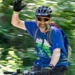 A cyclist grins and waves at the start of the Rails to Trails event spanning the Snoqualmie Valley June 24.                                Photo courtesy of Ray Lapine