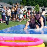 Chris and Jamie Teteak slip and slide their way to victory in the 2016 Festival at Mount Si wife-carrying contest. This year&rsquo;s event includes an under-21 event, a sibling-carrying competition to win your partner&rsquo;s weight in root beer.                                (Carol Ladwig/File Photo)