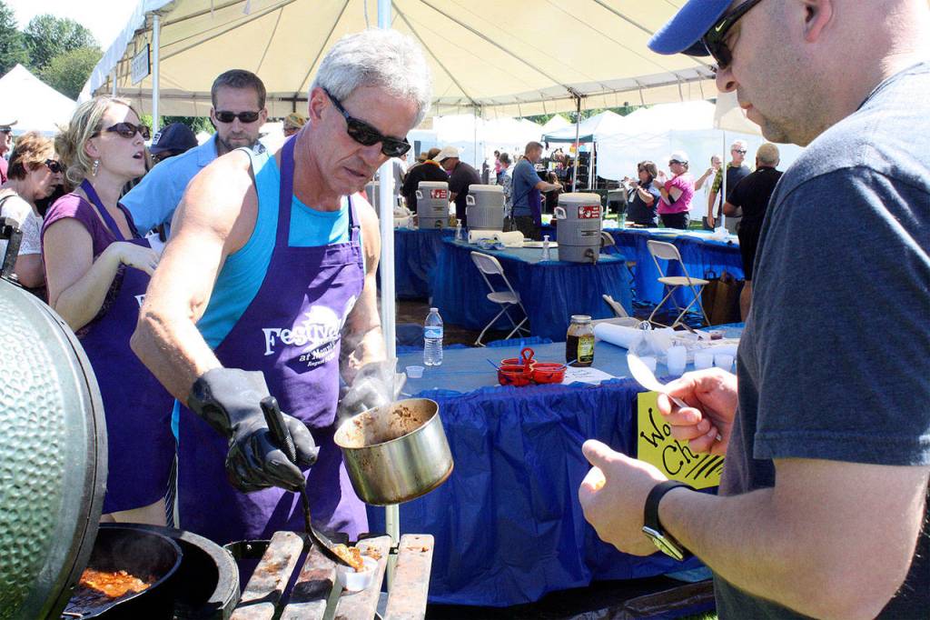Ben Cockman serves up a sample of chili in the 2015 cookoff. Cockman is the coordinator of this year&rsquo;s contest, which starts at 8:30 a.m. Sunday. Tasting for the People&rsquo;s Choice Awards is at 1 p.m.                                (Evan Pappas/File Photo)