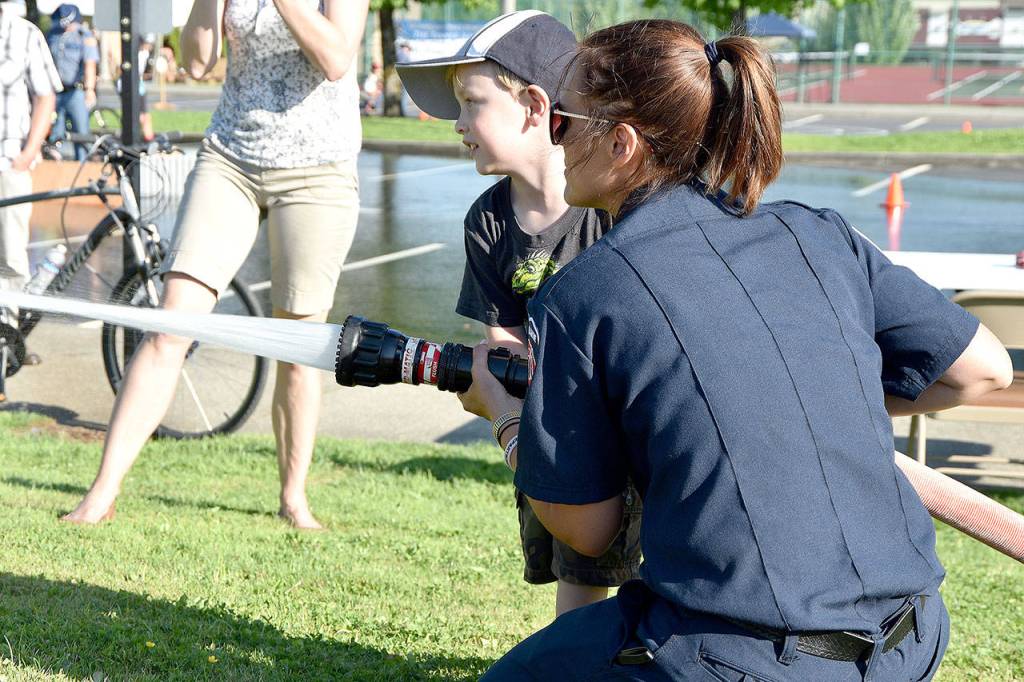 T.J. Wright Munden grins as he plays firefighter at the Tanner Jeans Bike Rodeo and National Night Out event Aug. 1.                                (Carol Ladwig/Staff Photo)
