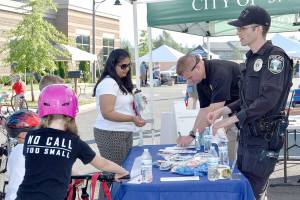 A family stops at sponsor Snoqualmie Police Department&rsquo;s booth Tuesday.                                (Carol Ladwig/Staff Photo)