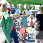 Kaley Seidenstucker, left and April Brown discuss CERT training with guests at the event Tuesday evening. Seidenstucker volunteered to model the stylish green vest that CERT students receive when they complete the class and sign up as volunteer emergency responders.                                (Carol Ladwig/Staff Photo)