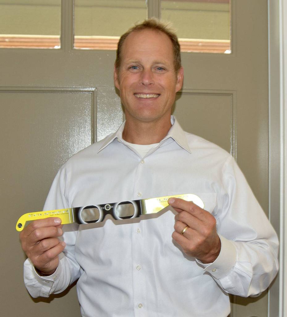Dr. Brian Duvall of Snoqualmie Valley Eyecare holds a pair of the free solar eclipse viewers his clinic is providing to customers who want to watch the Aug. 21 solar eclipse.                                (Carol Ladwig/Staff Photo)