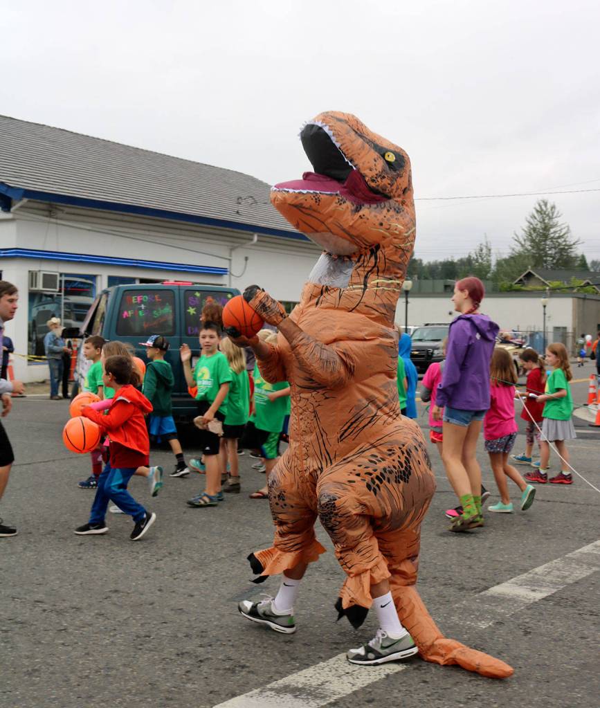 Si View Parks brought out a basketball playing dinosaur for their festival parade float.                                (Evan Pappas/Staff Photo)