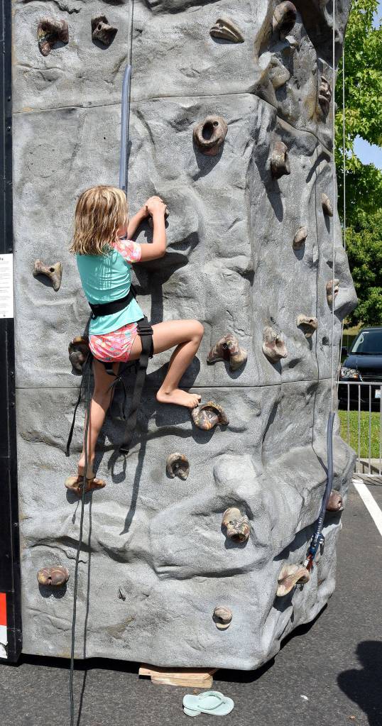 Claire Schultz, age 7, starts a lightning-quick climb to the top of the rock wall at the Snoqualmie Valley YMCA&rsquo;s fifth anniversary party Sunday on Snoqualmie Ridge. (Carol Ladwig/Staff Photo)