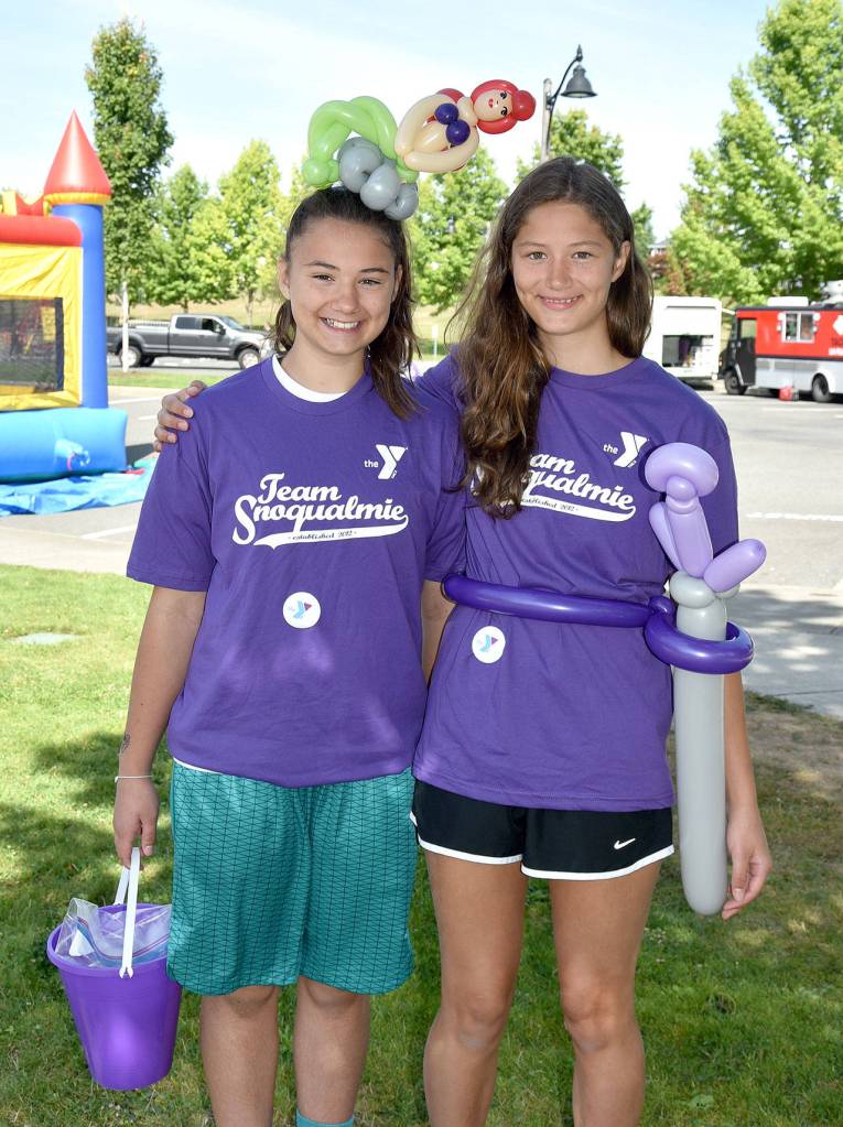 Volunteers Maddie and Gabi Parrish suit up for Sunday&rsquo;s celebration with balloon creations. (Carol Ladwig/Staff Photo)