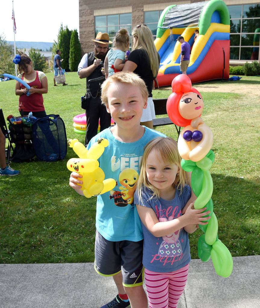 Nicholas and Stella Zacal, ages 8 and 4, proudly display their balloon animals, a Pikachu and a mermaid. (Carol Ladwig/Staff Photo)