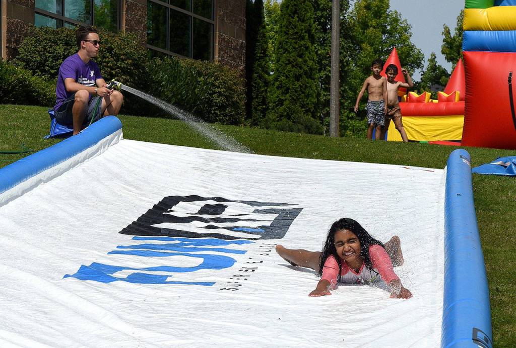 A giant slip and slide on the hillside was a popular attraction at the YMCA&rsquo;s anniversary party. (Carol Ladwig/Staff Photo)