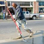 A contractor smooths out the surface of a new sidewalk, part of North Bend&rsquo;s downtown plaza project. Work on the project was stopped Friday, Aug. 18, because of an ongoing strike by Cal Portland cement workers that began a week ago.                                (Photo courtesy of Mary Miller)