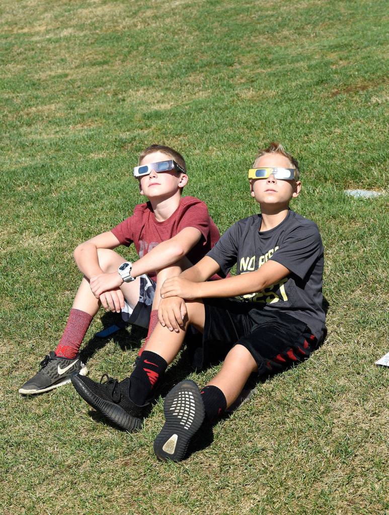 Cooper and Kolten, friends and neighbors of The Club at Snoqualmie Ridge, started their Monday at the 18th hole of the Boeing Classic, where they could watch the eclipse and the Seahawks fundraising tournament, Rumble on the Ridge.                                (Carol Ladwig/Staff Photo)