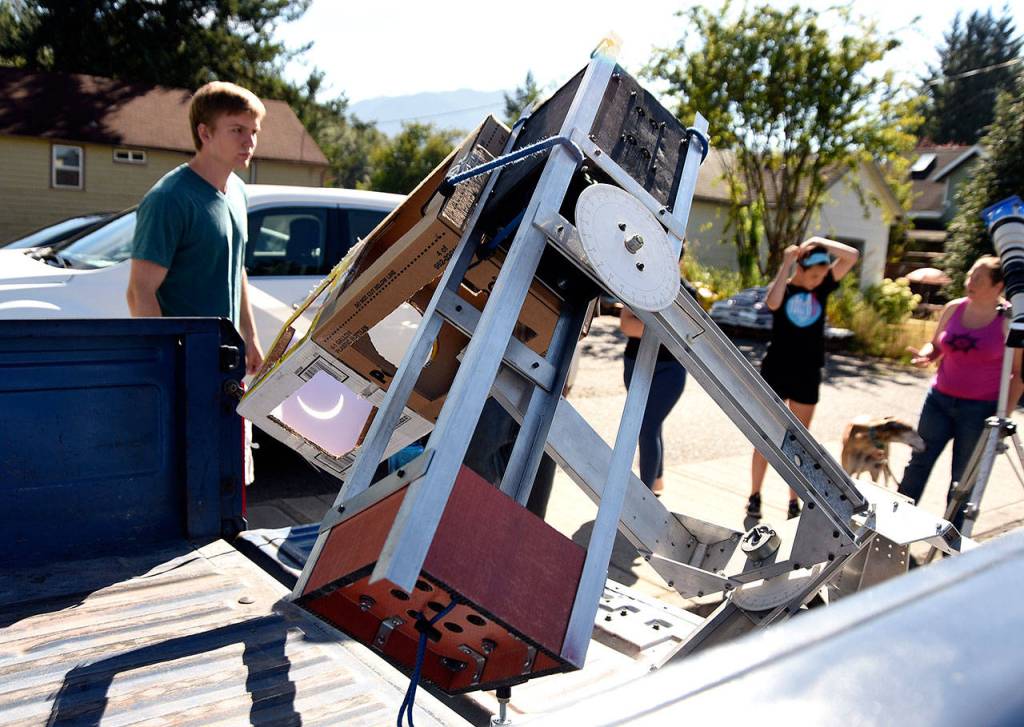 A large-format pinhole eclipse viewer, set up outside Carmichael&rsquo;s Hardware in downtown Snoqualmie, draw a small street party of eclipse watchers Monday morning.                                (Carol Ladwig/Staff Photo)