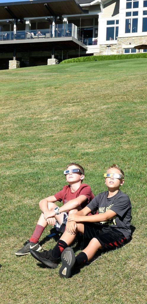 Cooper and Kolten, friends and neighbors of The Club at Snoqualmie Ridge, started their Monday at the 18th hole of the Boeing Classic, where they could watch the eclipse and the Seahawks fundraising tournament, Rumble on the Ridge.                                (Carol Ladwig/Staff Photo)