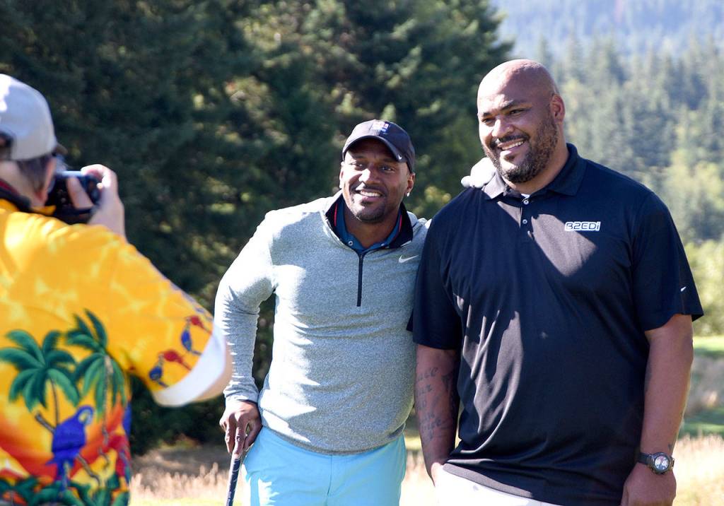 Football stars Jordan Babineaux and Walter Jones pose for a photo together during the Rumble on the Ridge fundraiser, Monday morning at The Club at Snoqualmie Ridge.                                (Carol Ladwig/Staff Photo)