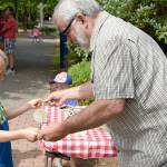 Dick Kirby, with the Snoqualmie Valley Historical Museum booth, helps a youngster named Matthew to get started with a toy called the buzz saw.                                (Carol Ladwig/Staff Photo)