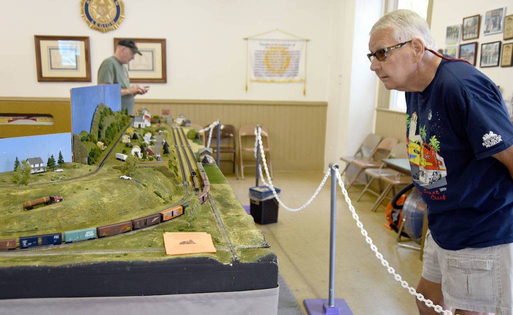 Bob Ufford, of Lynnwood, admires the model trains on display at the American Legion Hall during Railroad Days. He said he comes every year for the car show, but always has to stop and see the model trains, too.                                (Carol Ladwig/Staff Photo)