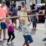 Children go to great lengths to bend under the limbo stick during the fun awards games at the Legends Car Show Sunday in Snoqualmie.                                (Carol Ladwig/Staff Photo)