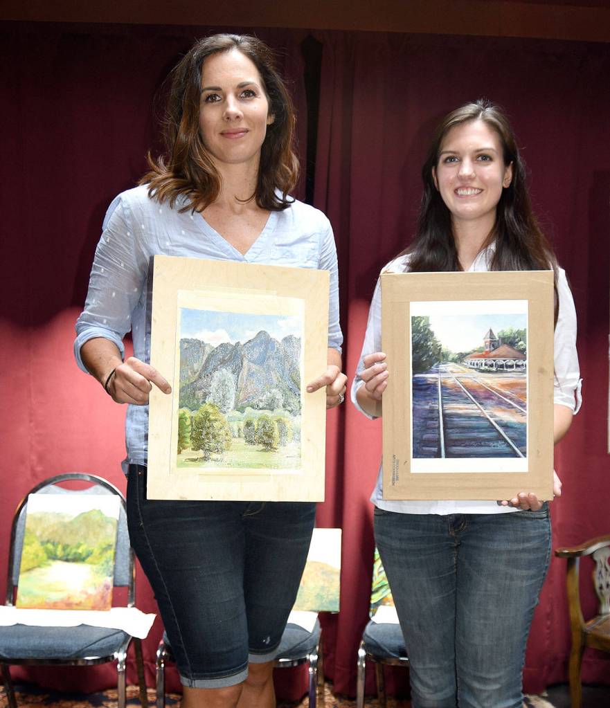 Winners of the Plein Air Paint Out Saturday are, from right, Jacqueline Tribble, first place; Sarah Sedgwick Anderson; and the third-place painting, on the chair, of Susan Jenkins, who was unable to attend the awards presentation, but left her completed entry in a pizza box for the judges.                                (Carol Ladwig/Staff Photo)