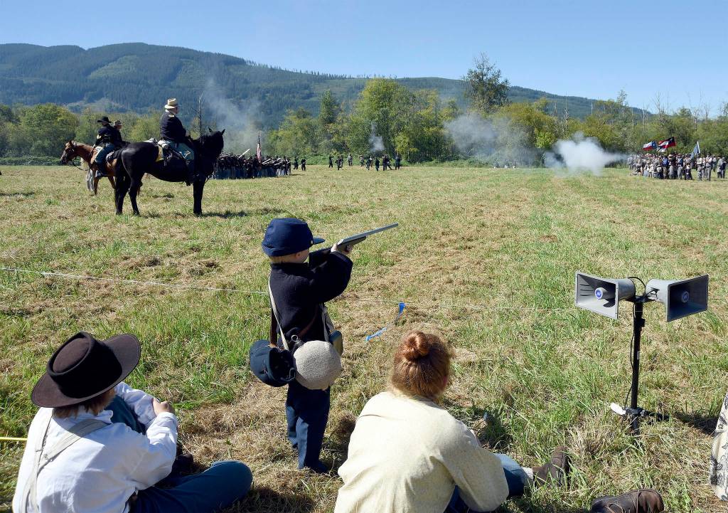 Every inch a Union soldier, 6-year-old Thomas House Higgins watches the 2016 Battle of Snoqualmie from the sidelines, and pretends to take part. His mother, Carolyn, left, said his father is a long-time volunteer with re-enactments.