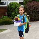 Duncan Maynard carries a flower arrangement for his teacher as Fall City Elementary School started the school year on Wednesday, Aug. 30. He starts the fourth grade. (Carol Ladwig/Staff Photo)