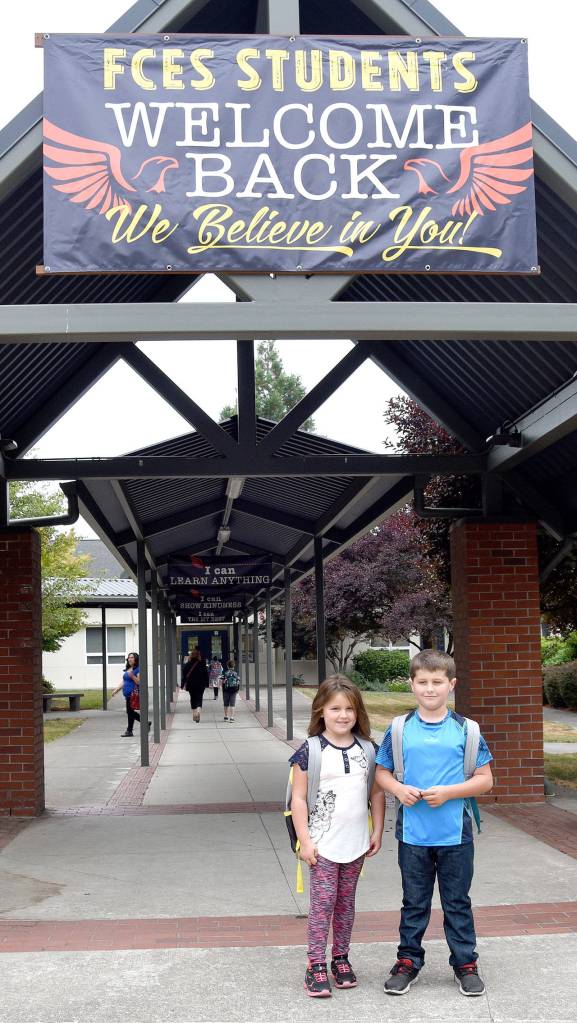 Melanie and Michael Sligh pose for a photo outside Fall City Elementary School before they head inside to start first and second grades, respectively. (Carol Ladwig/Staff Photo)