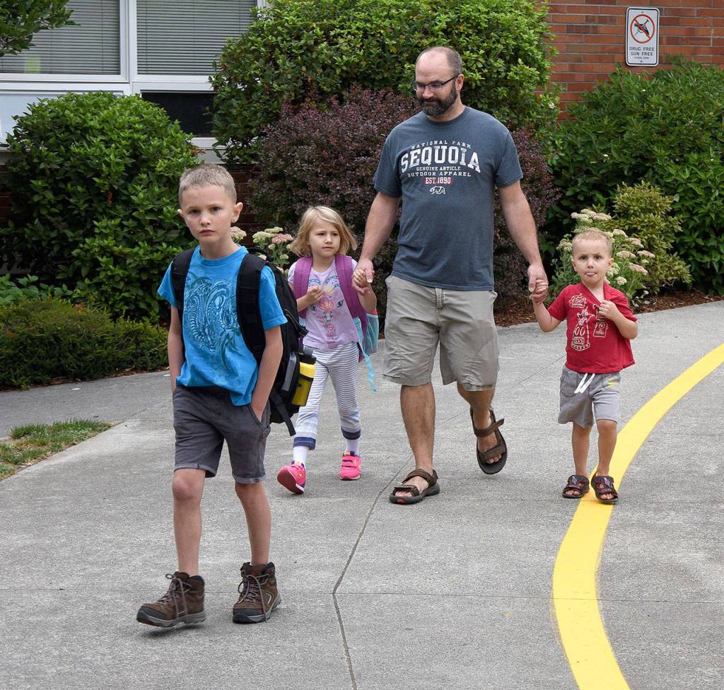 &ldquo;It&rsquo;s the most wonderful time of the year,&rdquo; says Mark Smith, after dropping off his son, Gibson, front, and daughter Camille, left, at their classrooms Wednesday. Bryson, right, starts preschool soon. (Carol Ladwig/Staff Photo)
