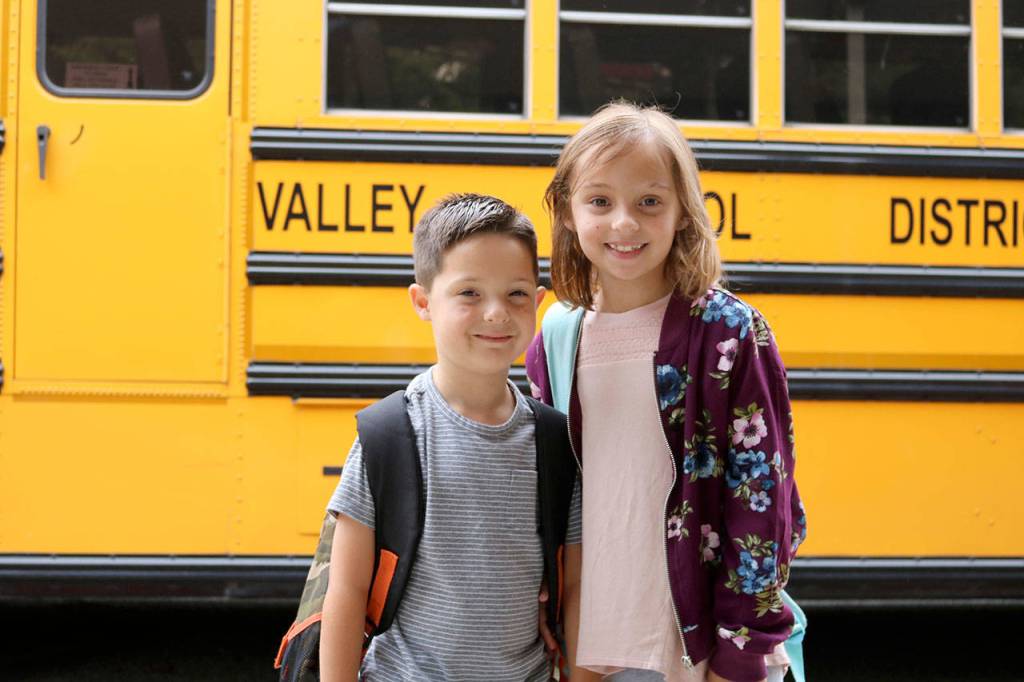 Aiden and Hadley Robbins went to see their friends at the Snoqualmie Elementary bus lane. (Evan Pappas/Staff Photo)