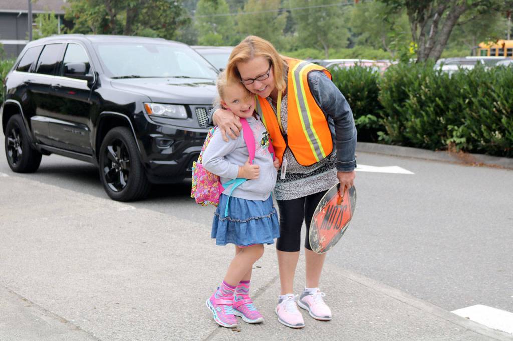 Desi Frink hugs crossing guard Joan Graves before excitedly entering the school for her first day of first grade. (Evan Pappas/Staff Photo)