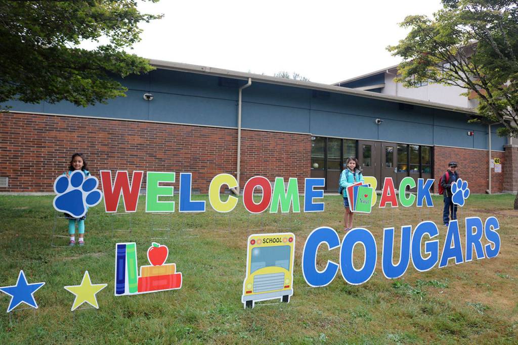 Eleanor, Eva and Alex McLean all stand by the welcome sign put up at Snoqualmie Elementary by the PTSA. (Evan Pappas/Staff Photo)