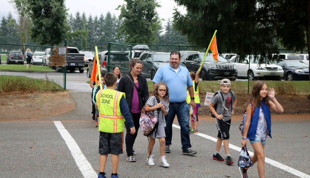 Student crossing guards lead parents and students from the parking lot to Snoqualmie elementary safely. (Evan Pappas/Staff Photo)