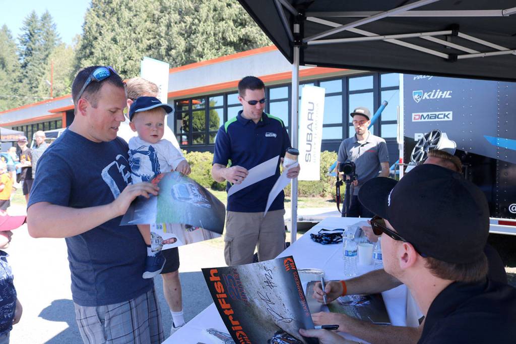 A father and son get a signed poster from James Rimmer.                                (Evan Pappas/Staff Photo)