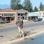 A concrete worker smooths out the new sidewalks poured two weeks ago as part of the North Bend downtown plaza project, another effort by the city to revitalize downtown. The block pictured here, along with businesses on the opposite side of the street, make up the city&rsquo;s Historic Downtown District. (Photo courtesy of Mary Miller)