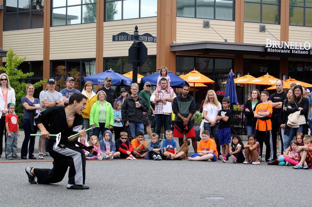 A crowd gathers to watch the DMW Martial Art and Fitness weapons demonstration on the corner of Center Boulevard and Southeast Ridge Street. (Evan Pappas/File Photo)