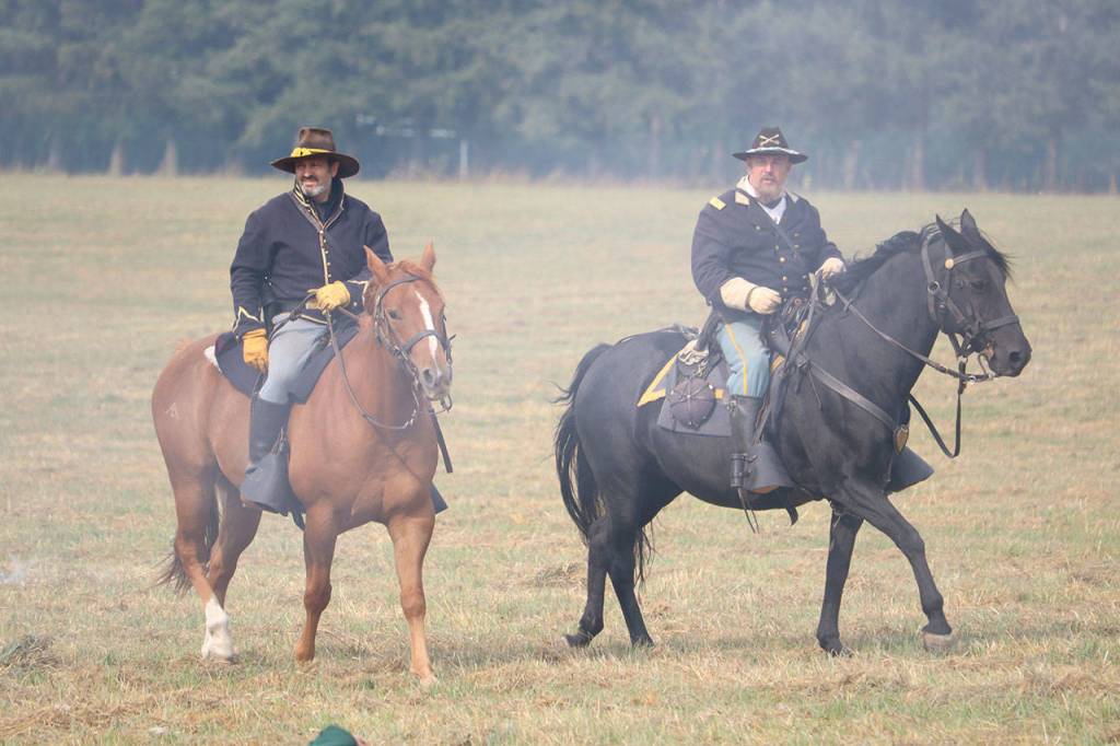 Two cavalrymen ride through the smoke caused by cannon fire. (Evan Pappas/Staff Photo)