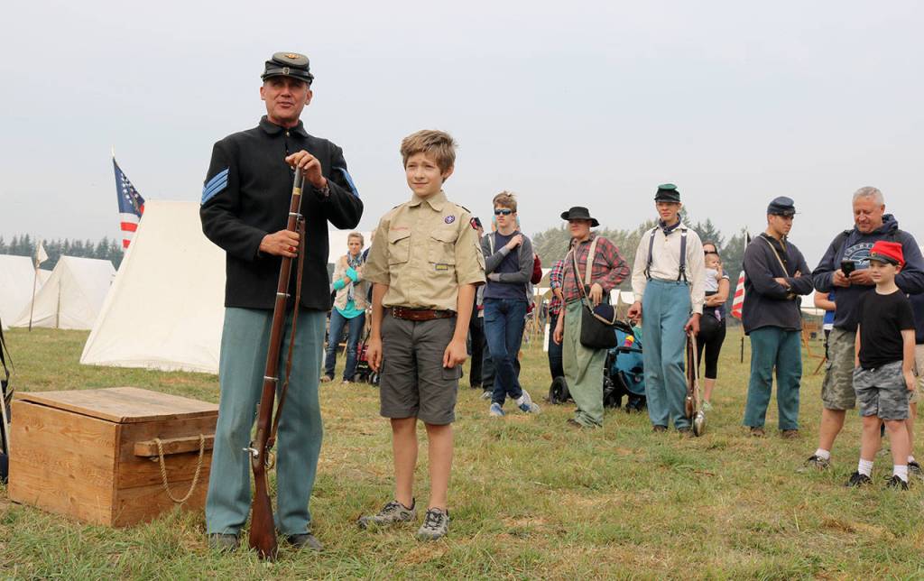Cap Caputo, gives a presentation to the crowd about how new soldiers were recruited to fight in the civil war. Daniel Kolke, 11, volunteered to help Caputo&rsquo;s presentation. (Evan Pappas/Staff Photo)