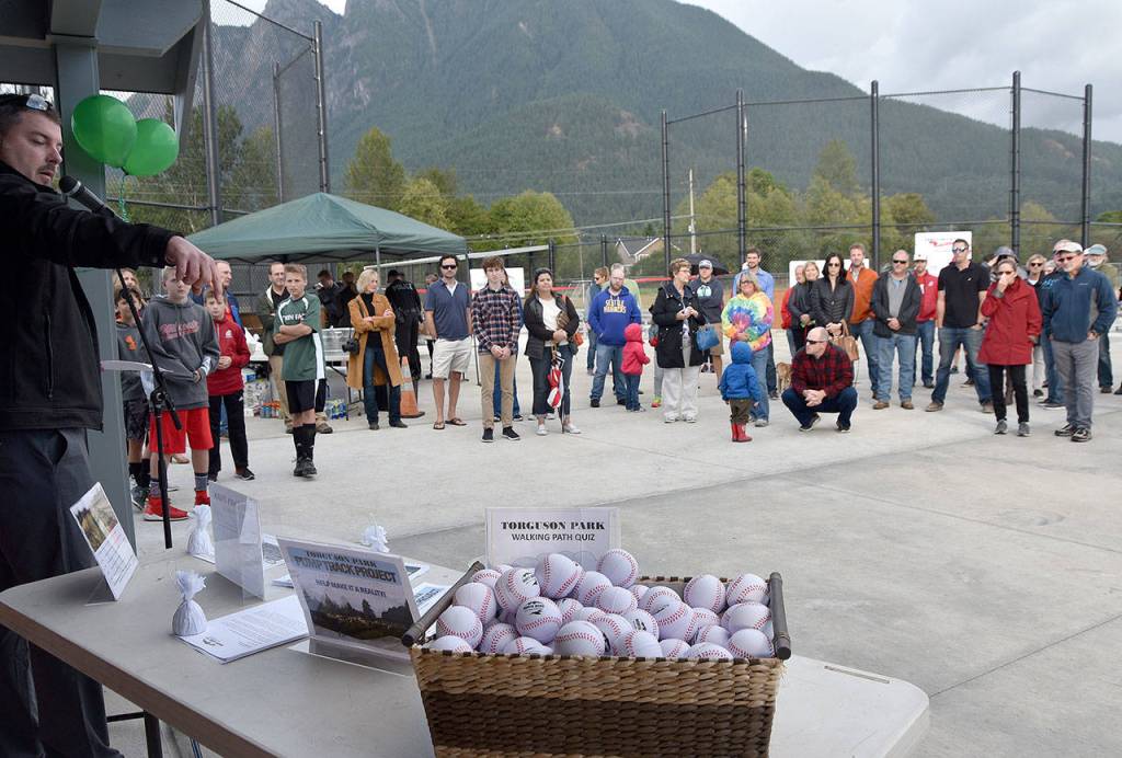 North Bend Public Works Director Mark Rigos points out the game to guess the length of the new walking trail, one of the latest park improvements celebrated Sept. 14 at North Bend&rsquo;s Torguson Park. (Carol Ladwig/Staff Photo)