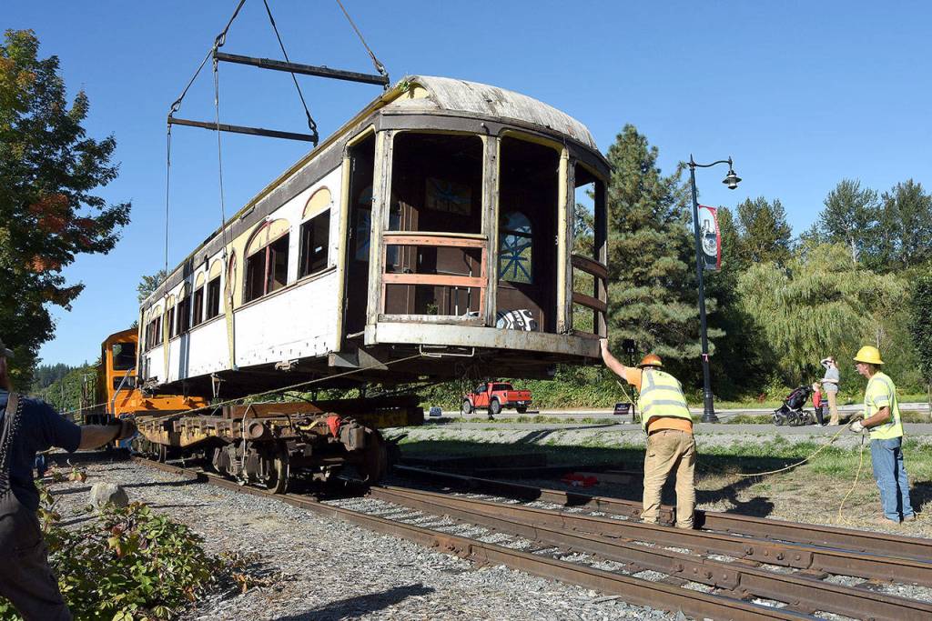 With the car lined up with the flatbed, volunteers began the work of adding supports to hold the car steady for its next move, down the tracks. (Carol Ladwig/Staff Photo)