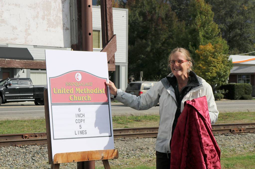 Pastor Lee Carney Hartman unveils the new sign for the United Methodist Church paid for by the Charles Peterson Memorial Fund. (Evan Pappas/Staff Photo)