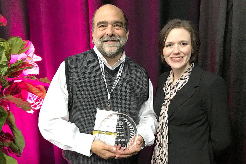 Vitamin Packs founder Jason Brown, left, accepts the Editor&rsquo;s Choice Award from Ginger Schlueter, assistant editor of Natural Products INSIDER. (Photo courtesy of Informa)