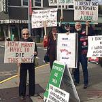 Members of Snoqualmie Valley Indivisibles dressed in black and waved signs calling for gun control, Oct. 8, in downtown North Bend. (Courtesy Photo)