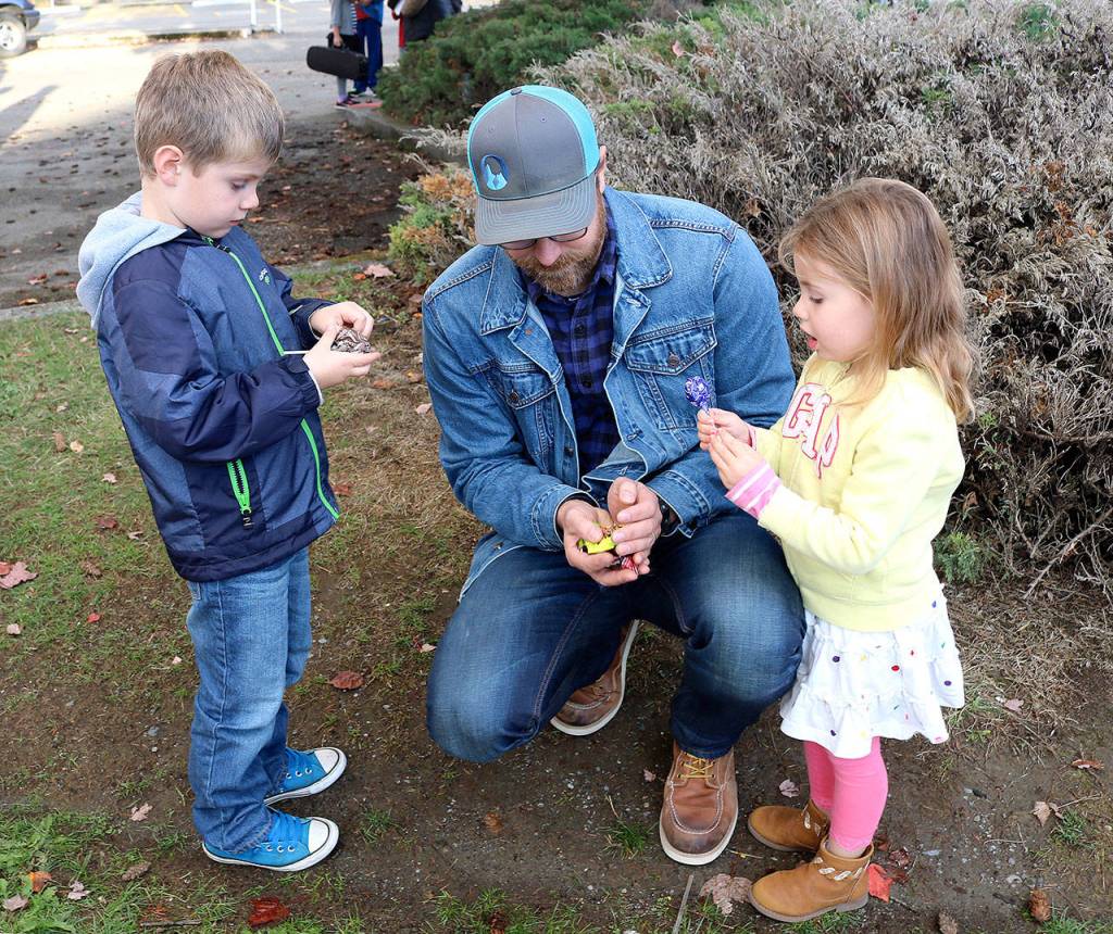 Teacher Bryce Meserve sorts through the candy collected by his children, Weston, 6 and Molly, 4, at Friday&rsquo;s Homecoming parade. (Carol Ladwig/Staff Photo)