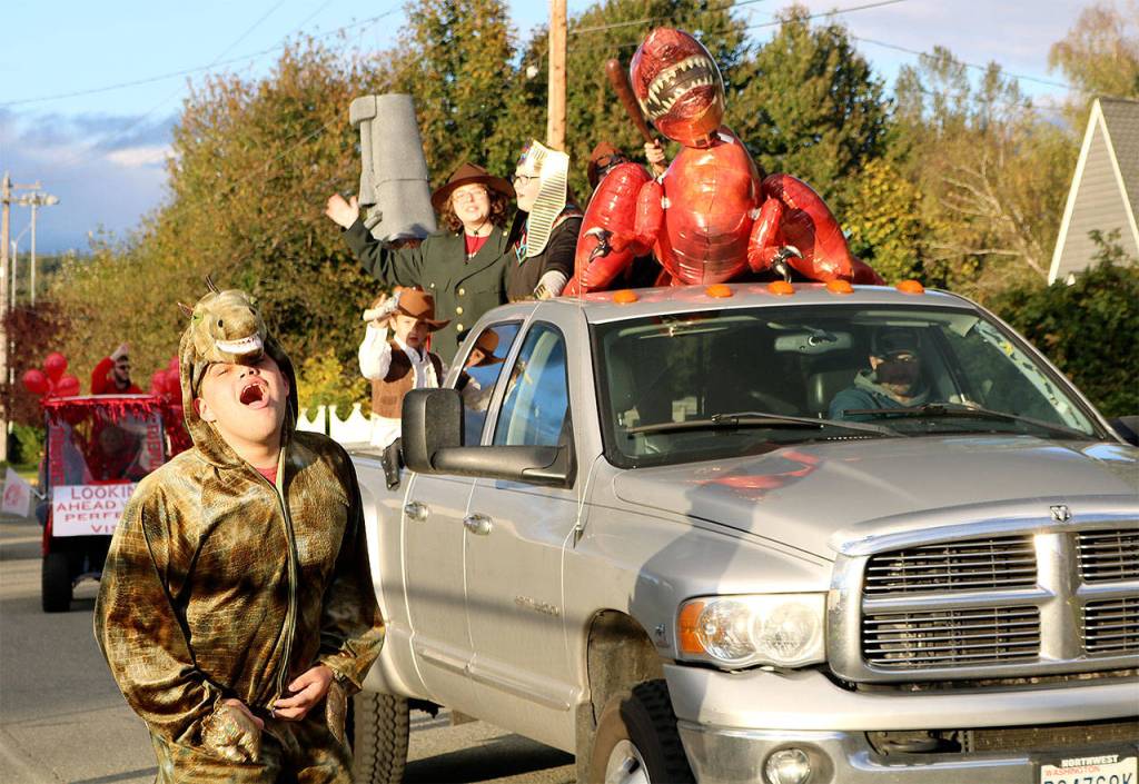 Parker Graves roars as the dinosaur in this float, themed &ldquo;A Night at the Museum.&rdquo; (Carol Ladwig/Staff Photo)