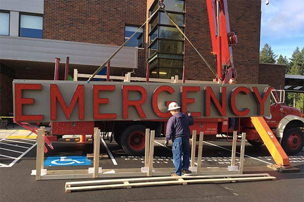 Workers install Snoqualmie Valley Hospital&rsquo;s new Emergency Room sign in 2015. (Courtesy Photo)