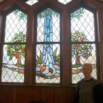 Tona McGuire stands with one of her favorite pieces in the church depicting Snoqualmie Falls and based on psalm 1:3. (Evan Pappas/Staff Photo)